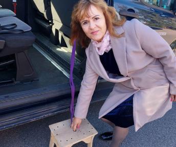 Lietuvos žmonių su stuburo pažeidimais asociacijos Alytaus miesto ir rajono skyriaus vadovė Gema Šakinienė demonstruoja įlipimo suoliuką su šniūreliu.